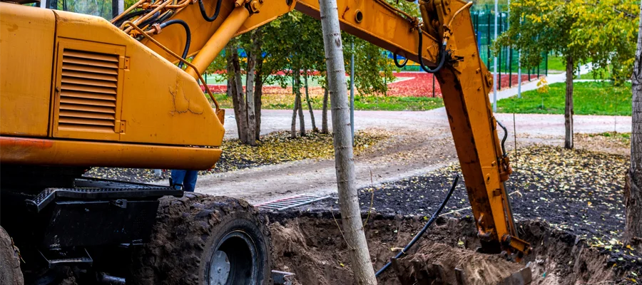 Excavator digging a trench for site development in Woodland, CA, showcasing Ibarra Construction's excavation services.