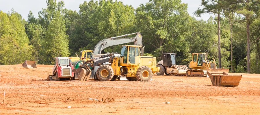 Excavators and construction machinery on a cleared site, emphasizing expert site grading and land preparation for stable foundations and proper drainage.