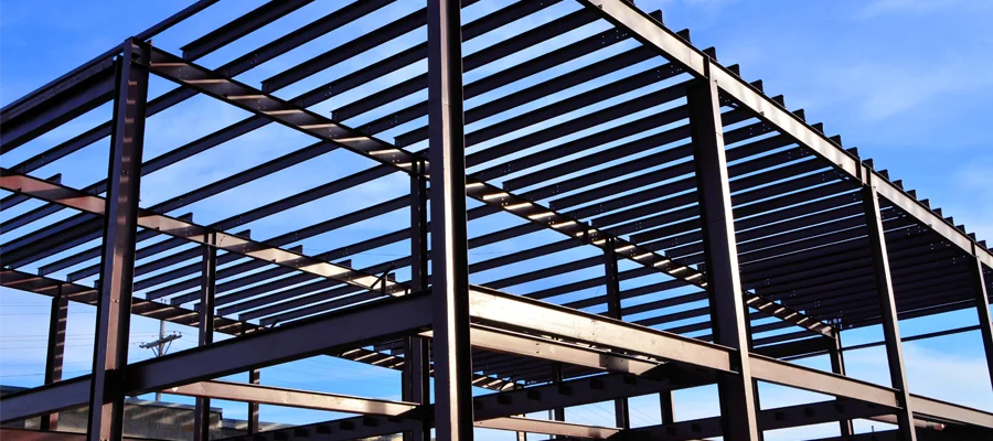 Metal steel structure framework under construction against a blue sky, showcasing Ibarra Construction's expertise in durable commercial building solutions.