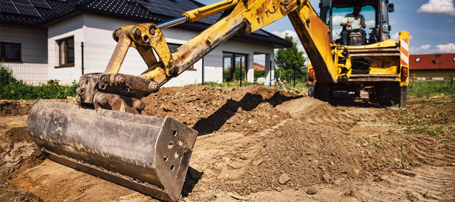 Excavator performing site preparation and grading work for residential construction in Woodland, CA.
