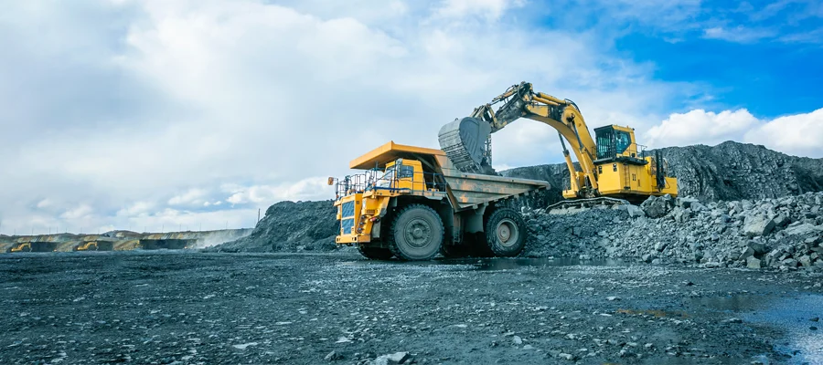 Excavation equipment including a large yellow excavator and dump truck on a construction site, illustrating Ibarra Construction's excavation services in Woodland, CA.
