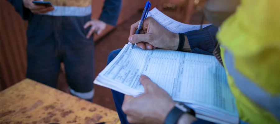 Construction worker completing permit paperwork for project compliance and approvals.