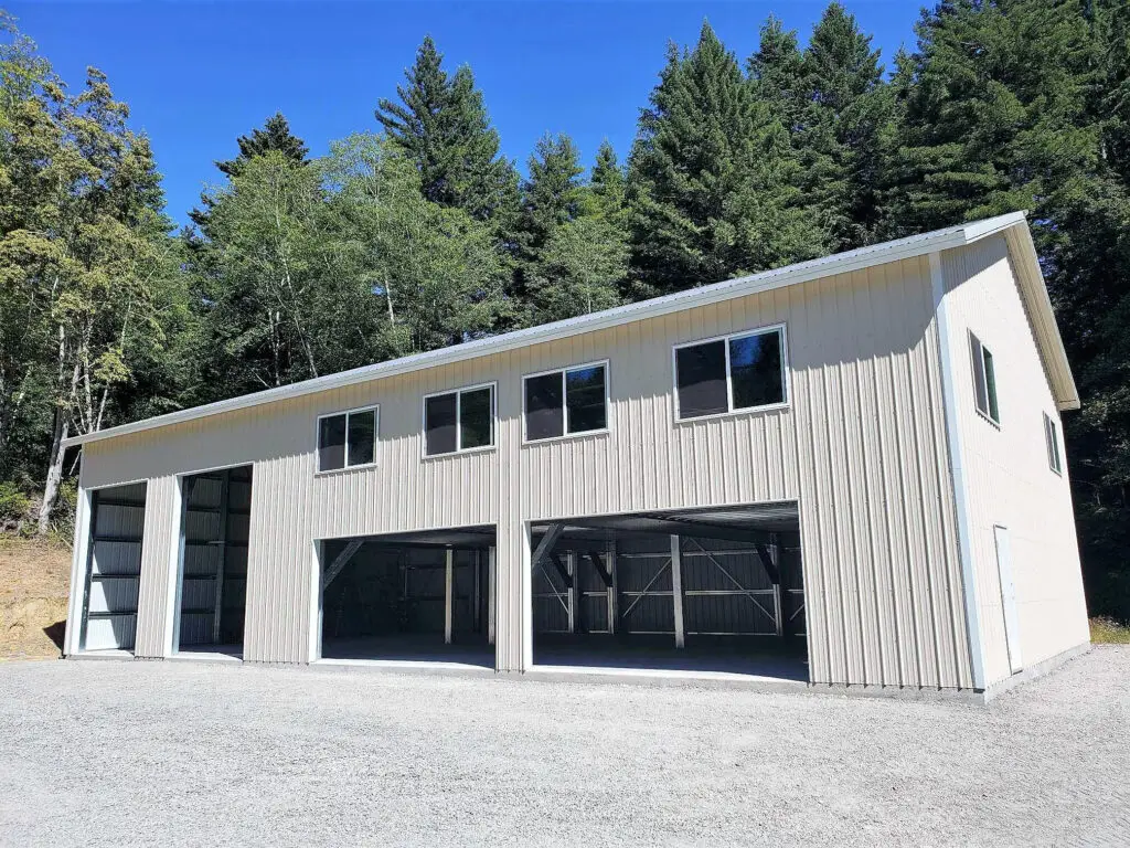 Metal building construction with garage doors and windows, showcasing durable steel building design.