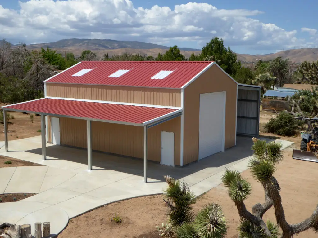 Custom gable metal building with red roof and extended awning, Ibarra Construction Services.
